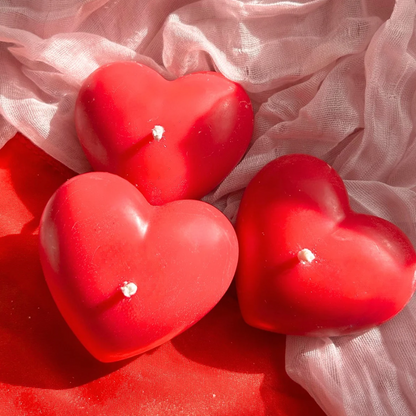 Three decorative full heart candles stacked together, sweet strawberry-scented with a smooth wax finish, perfect for gifts or home decor.