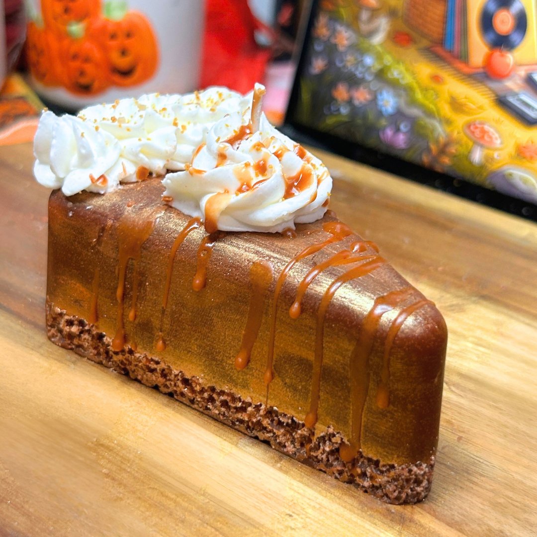 Golden Pumpkin Pie decorative candle shaped like a slice of pumpkin pie, featuring a crumb-textured base, golden top layer, whipped cream, crumbs, and syrup details.
