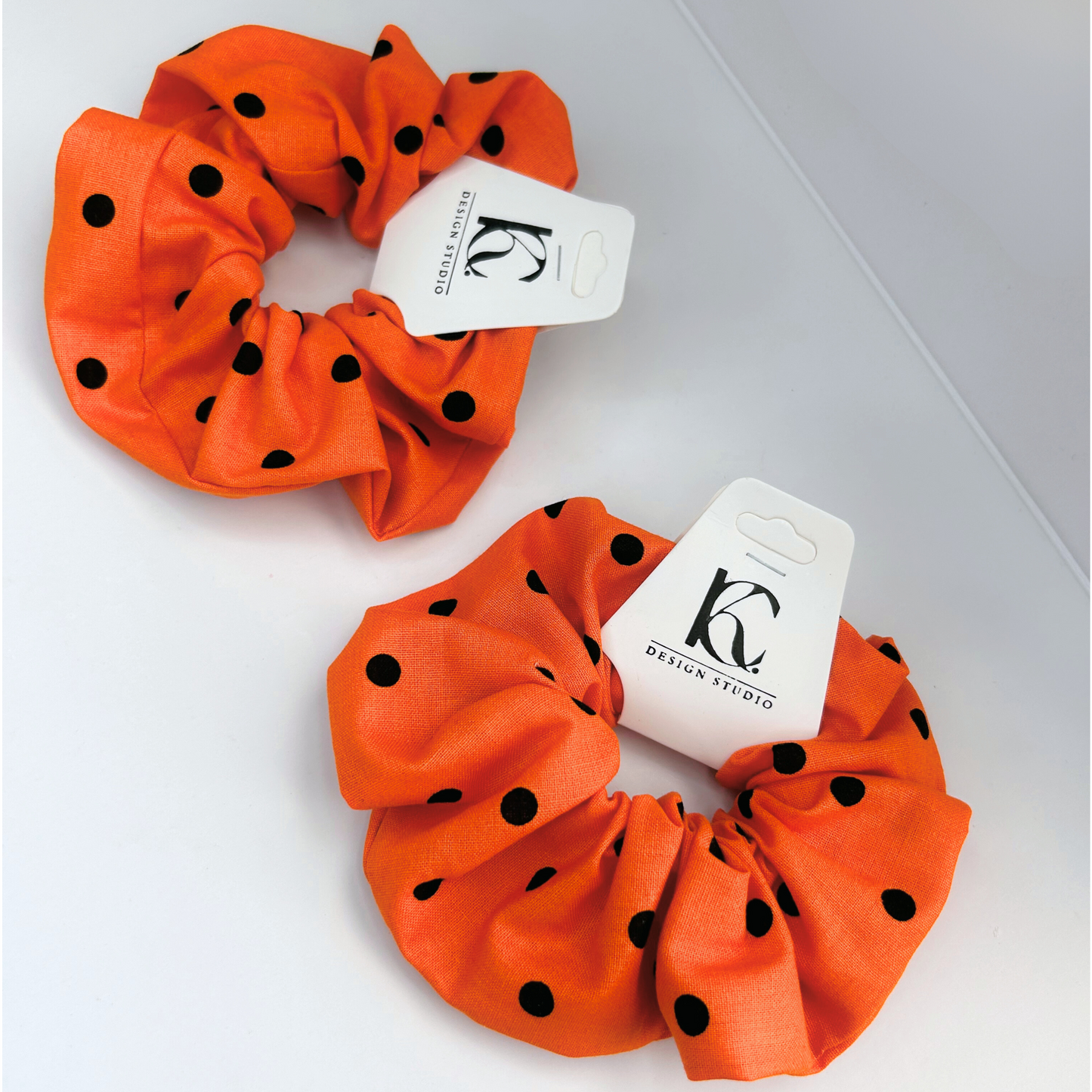 Top view of Halloween scrunchie in orange with black polka dots, handmade from premium cotton.