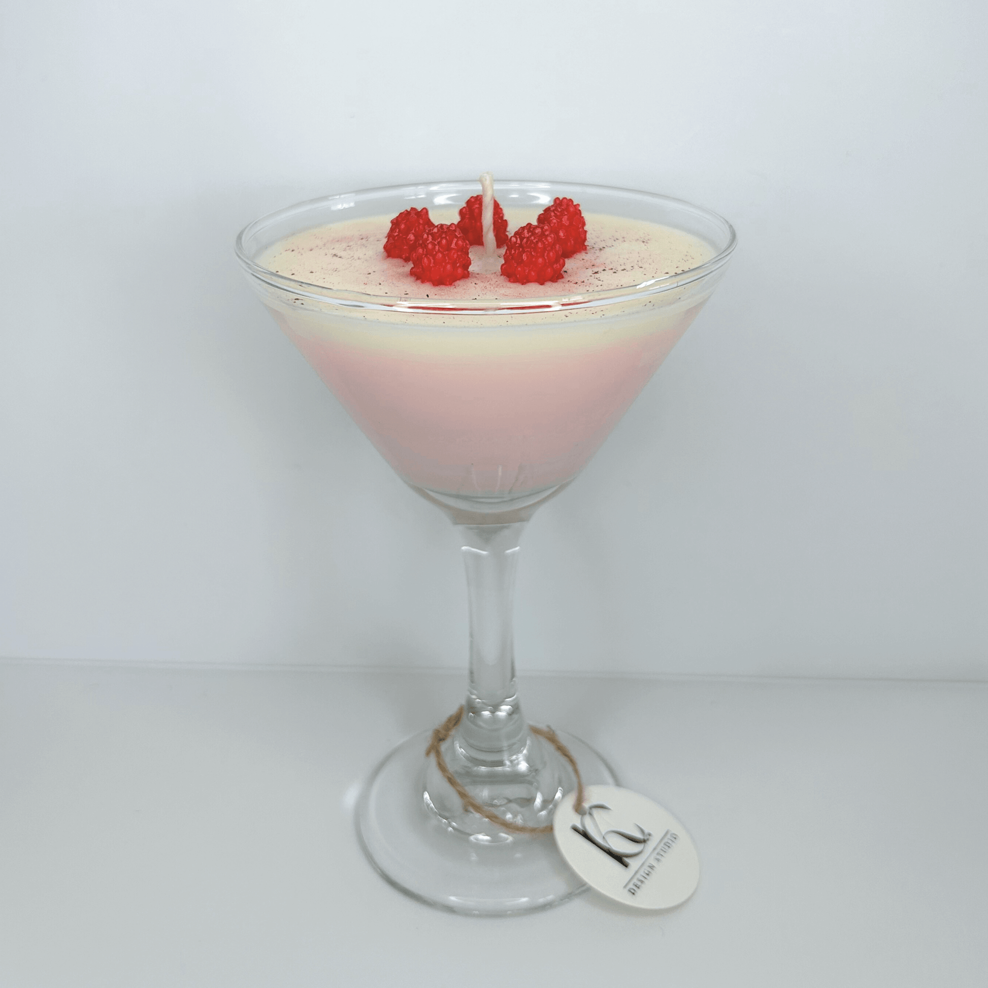 Handmade Raspberry Martini Candle in glass martini cup with mini raspberries, featuring vanilla buttercream, pink grapefruit, and sweet strawberry scents.