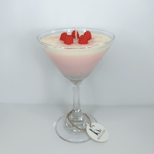 Handmade Raspberry Martini Candle in glass martini cup with mini raspberries, featuring vanilla buttercream, pink grapefruit, and sweet strawberry scents.