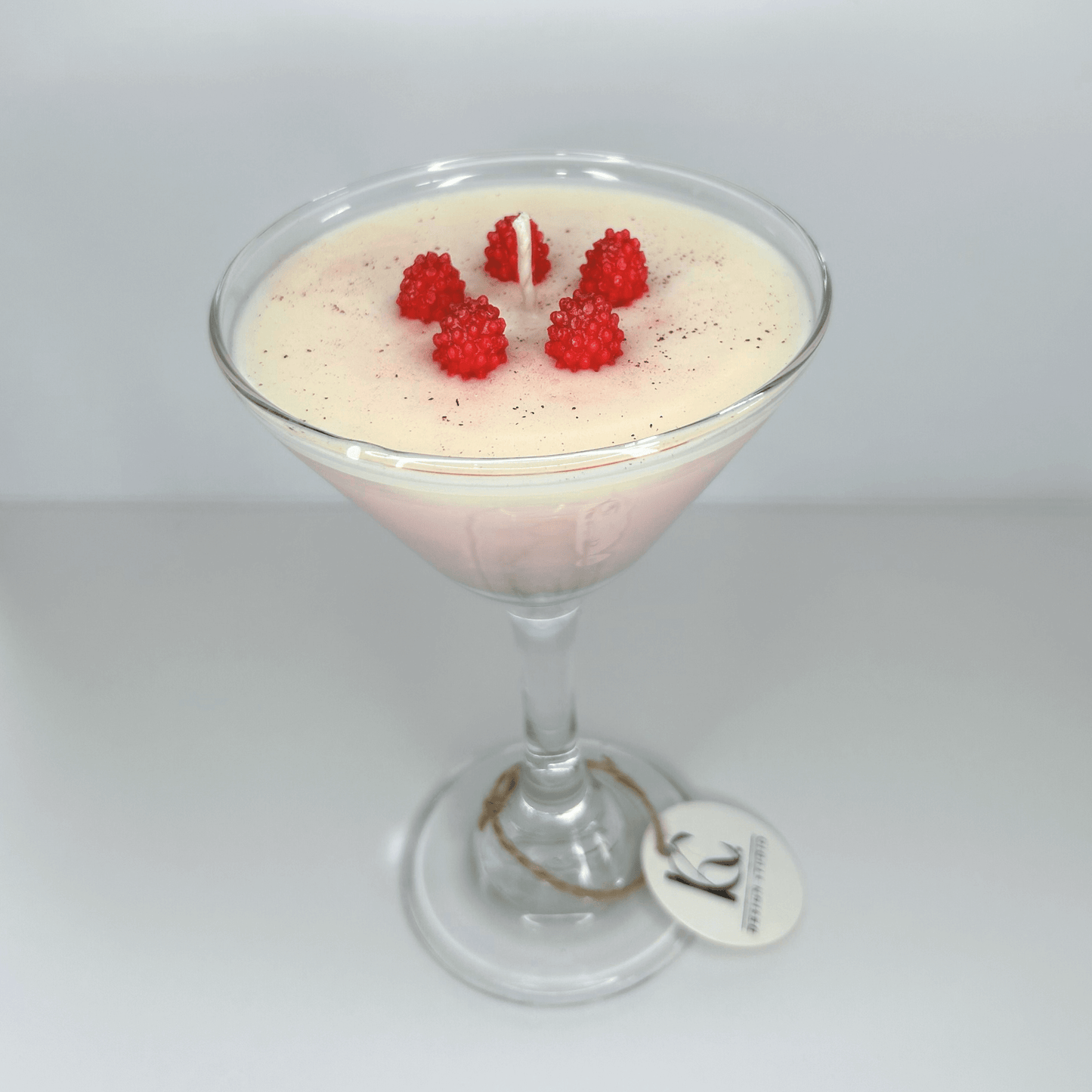 Handmade Raspberry Martini Candle in glass martini cup with mini raspberries, featuring vanilla buttercream, pink grapefruit, and sweet strawberry scents.