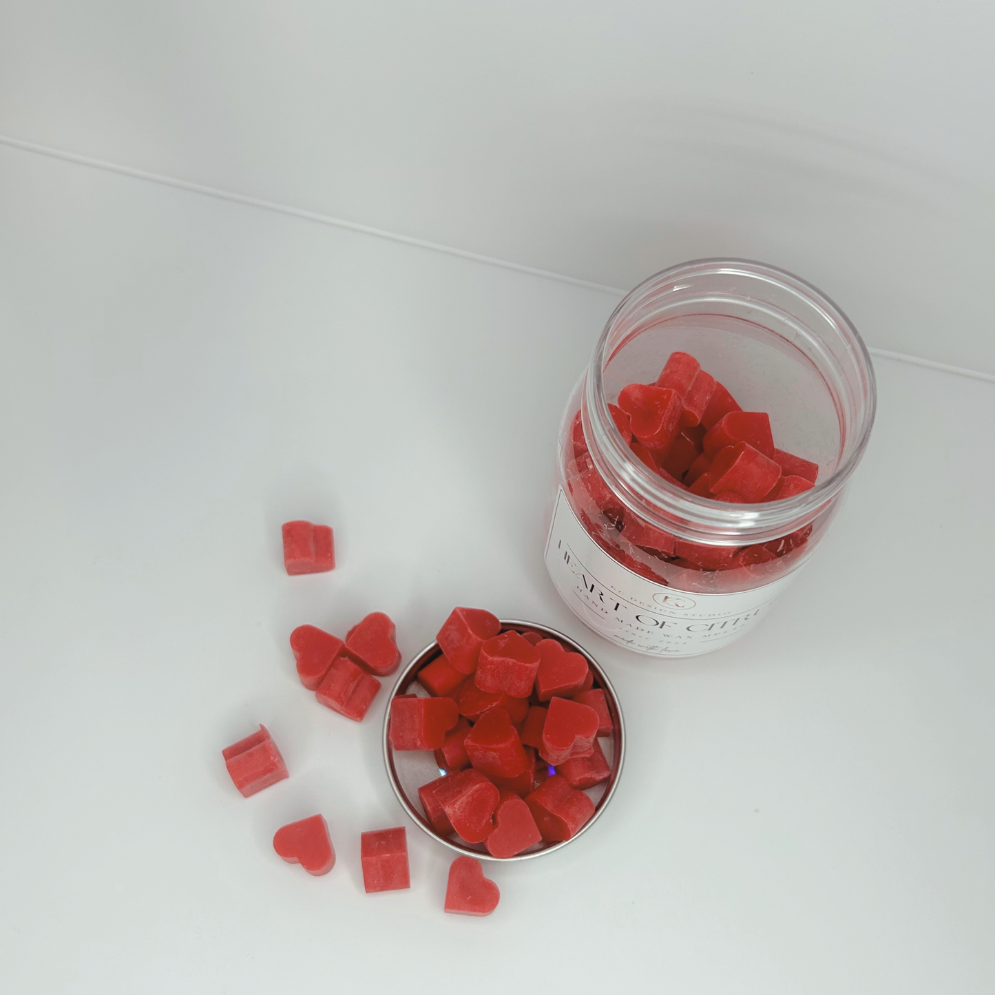 Top view of Heart of Citrus Wax Melts jar, showcasing the vibrant wax hearts inside and outside on the lid.