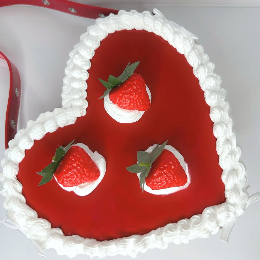 Top view of a heart-shaped strawberry cake-inspired purse with detailed frosting and strawberry decorations.