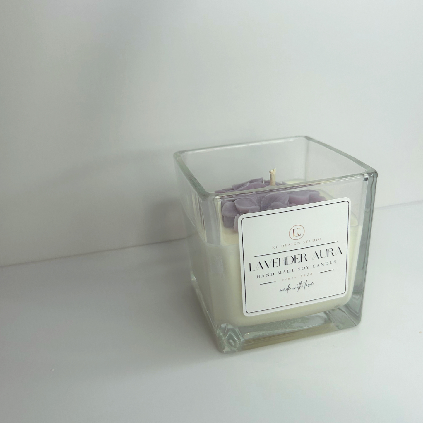 Angled view of the 10oz Lavender Aura Candle, emphasizing its square shape, elegant design, and calming lavender aroma.