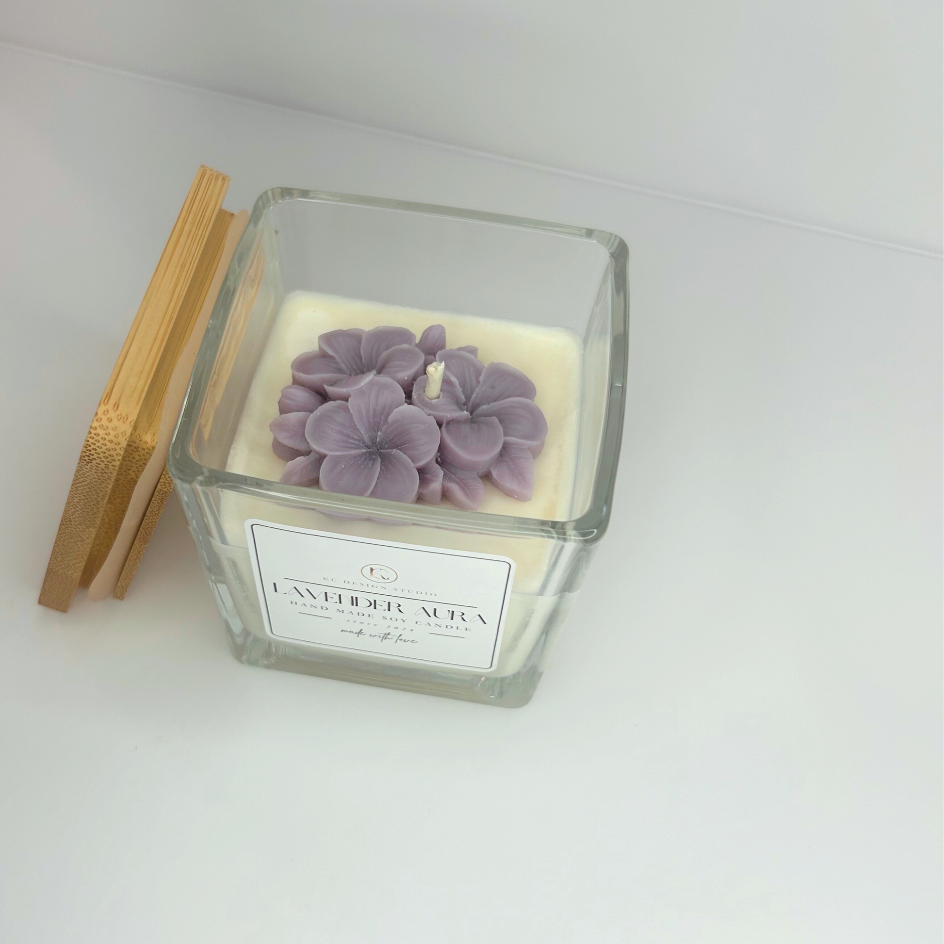 Top view of the 10oz Lavender Aura Candle with the lid resting on the side, highlighting the beautiful wax flower detailing and inviting aroma.