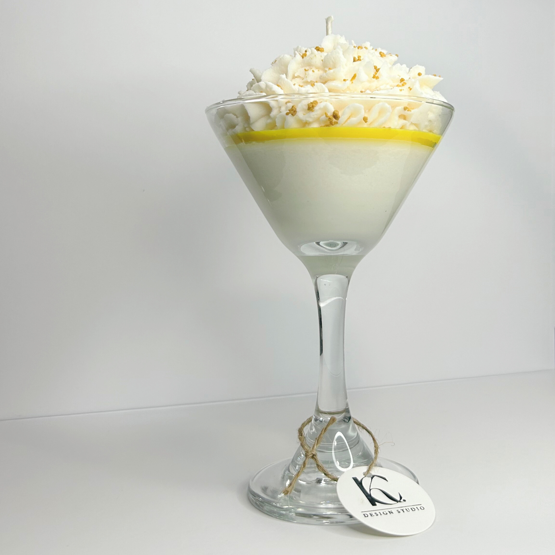 Bottom view of Lemon Meringue Martini Candle in martini glass, highlighting the eco-friendly wick and 100% natural soy wax, with detailed view of the base.