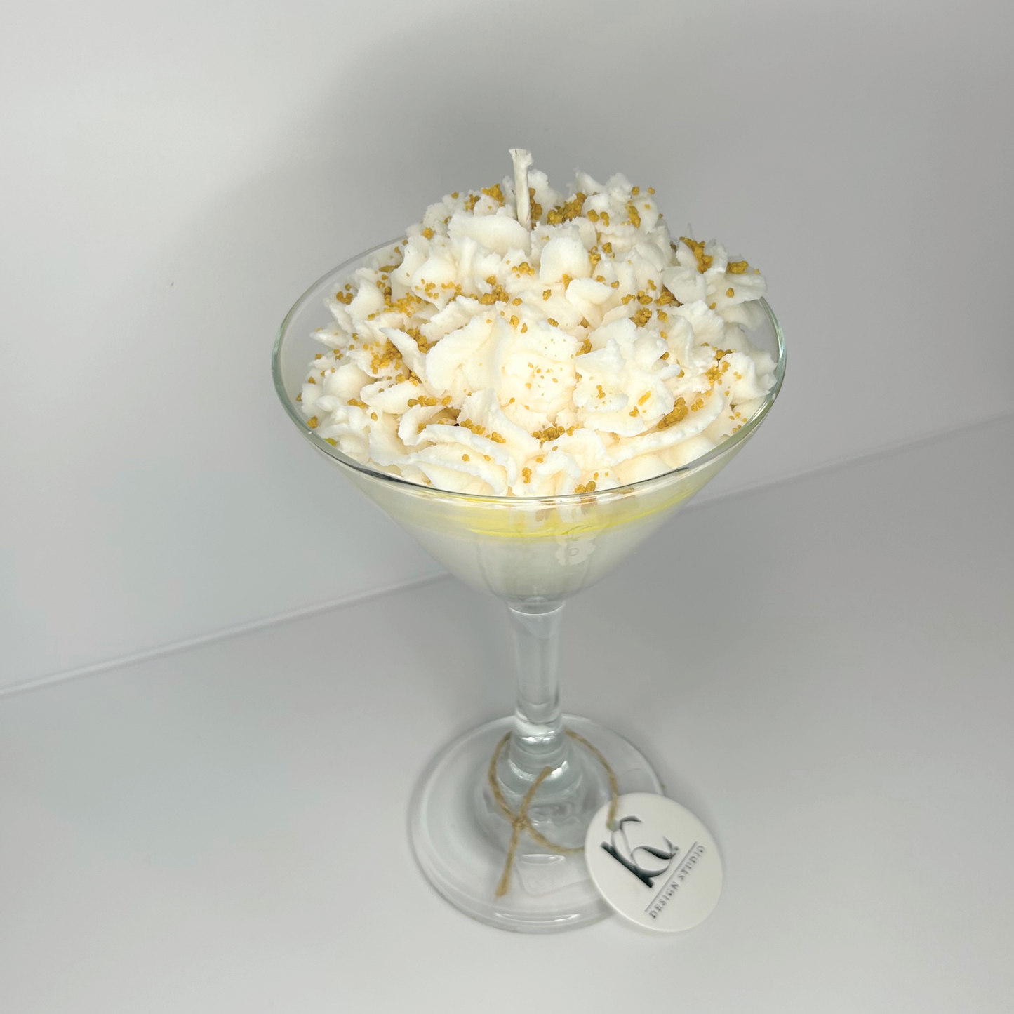 Close-up of Lemon Meringue Martini Candle inside a chic martini glass, detailed with whipped cream and caramel crumbs.