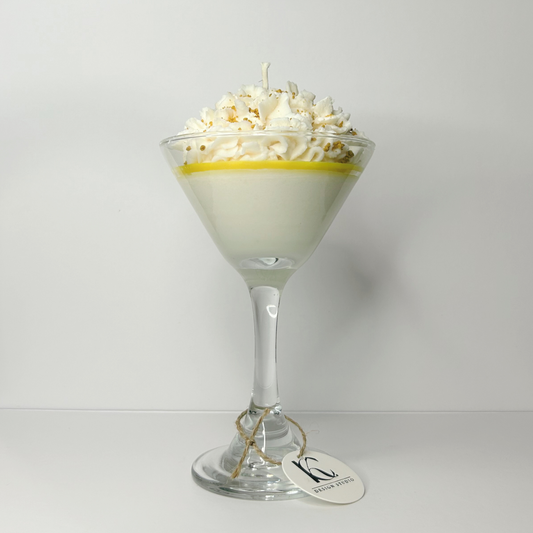 Front view of Lemon Meringue Martini Candle in martini glass, showcasing whipped cream, vanilla buttercream, lemon sugar cookie, and caramel crumbs.