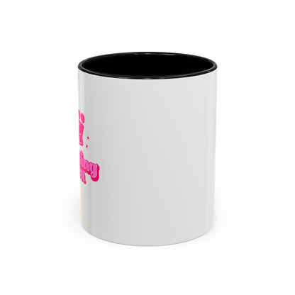 White mug with black interior and pink text on a white background