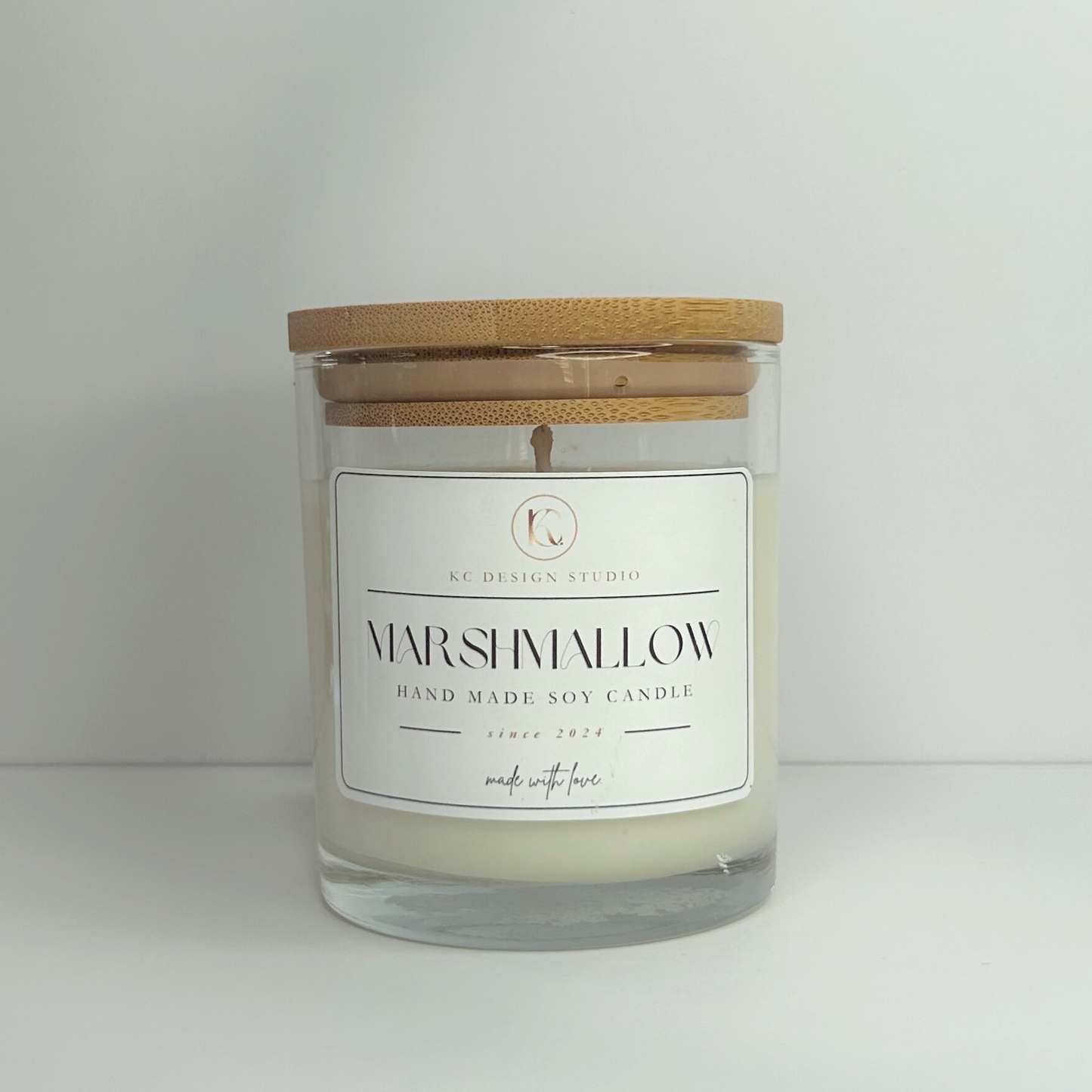 Front view of the 10oz Marshmallow Candle with the lid on, emphasizing its delightful design and delicious fire-roasted marshmallow scent.