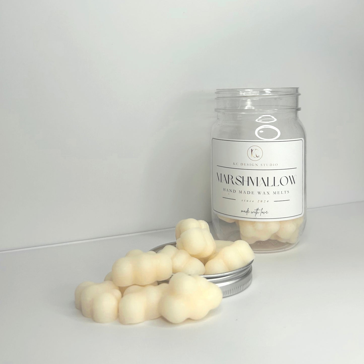 Front view of Marshmallow Cloud wax melts displayed outside the jar, highlighting their unique shape and label.