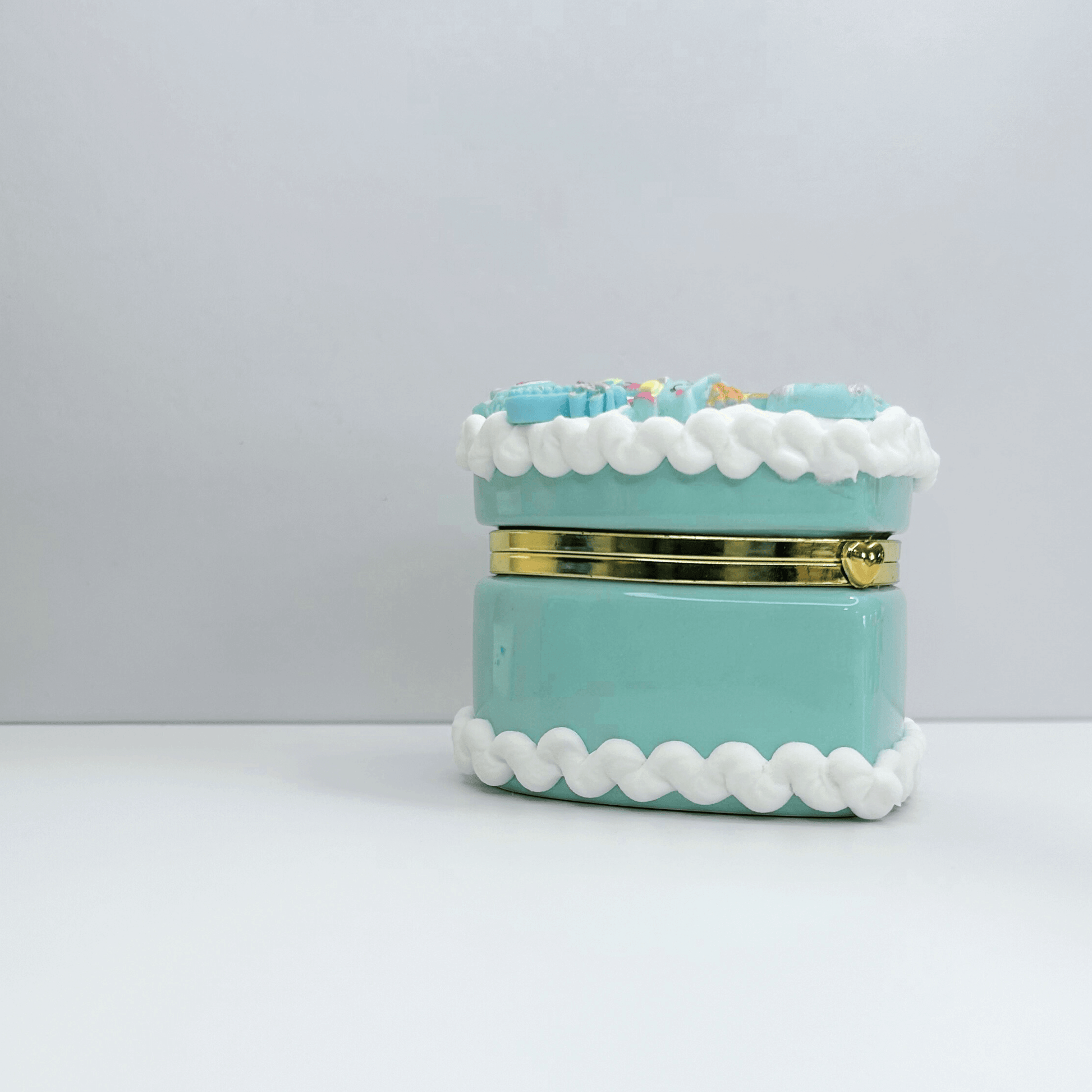 Front view of mini blue kawaii heart-shaped jewelry box featuring a cherry on top and adorable decorations.