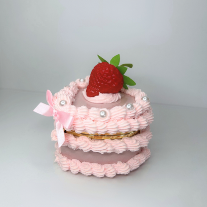Side view of the Mini Strawberry Cake Jewelry Box, featuring a heart-shaped design, soft pink bow, shiny pearls, and a realistic strawberry on top.