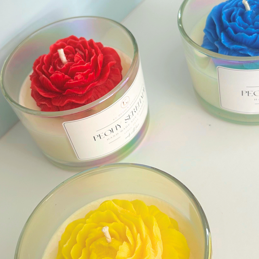 Top, close-up view of all three Peony Serenade Candle variants in red, blue, and yellow colors.