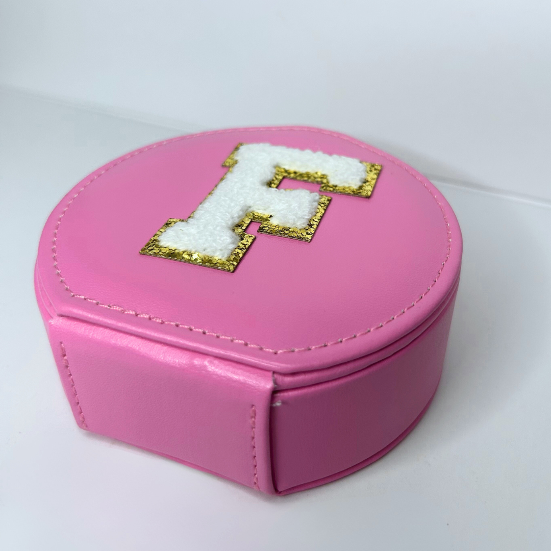 Side view of pink round jewelry travel case showing flat bottom.