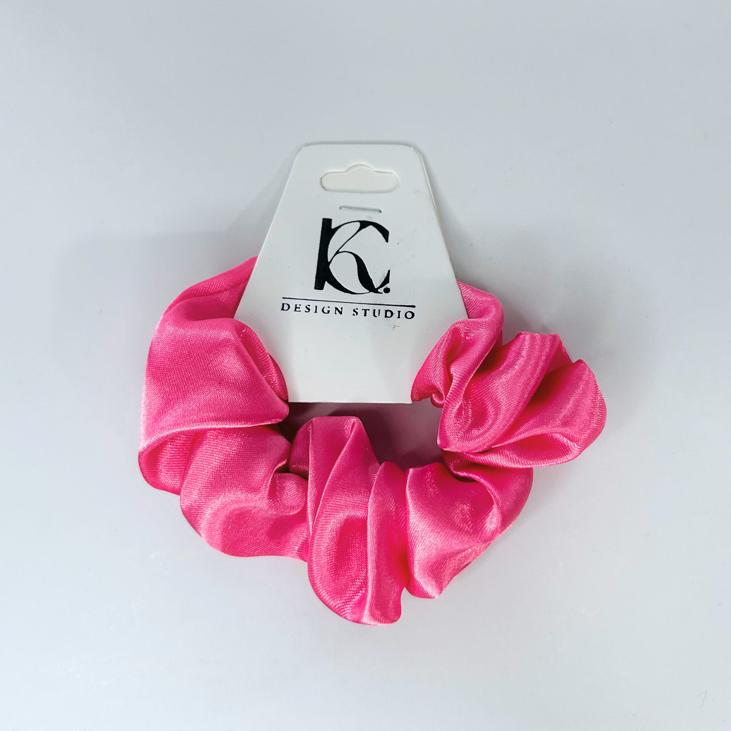 Soft pink silk scrunchie adding a feminine touch to any hairstyle.