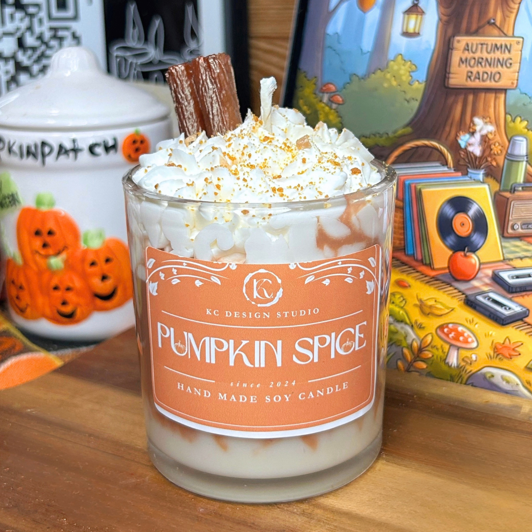 Pumpkin Spice Latte candle in a 10oz glass vessel with a white and brown layered wax design, topped with white whipped wax, brown crumbs, and a cinnamon stick.