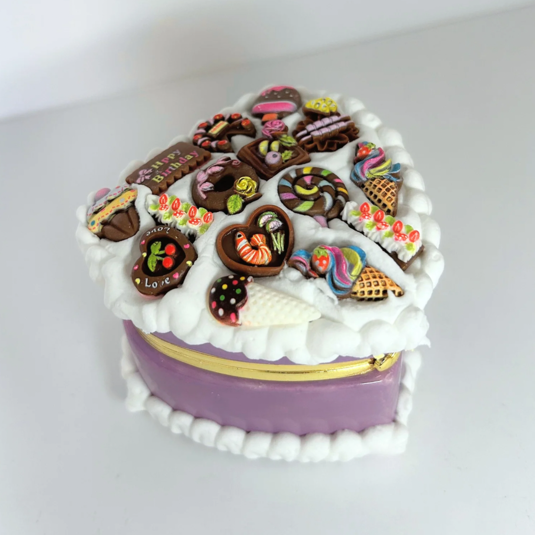 Close-up of a purple kawaii mini heart-shaped jewelry box with curvy cream and adorable charms.