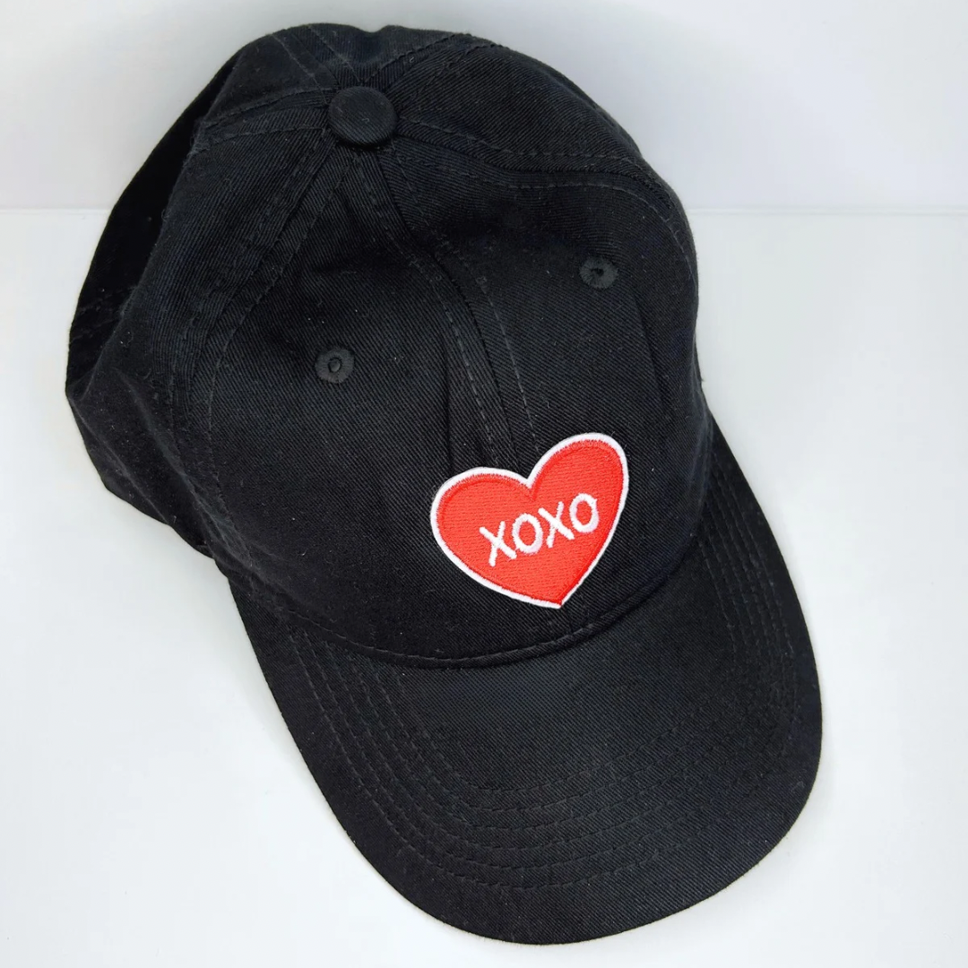 Red XOXO heart design cotton cap with breathable fabric and adjustable strap, perfect for sun protection and sweat-wicking during outdoor activities.