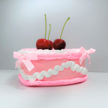 Side view of the pink and white jewelry box featuring three cherries, delicate pearls, and cute mini pink bows, highlighting its decorative details and stylish appearance.