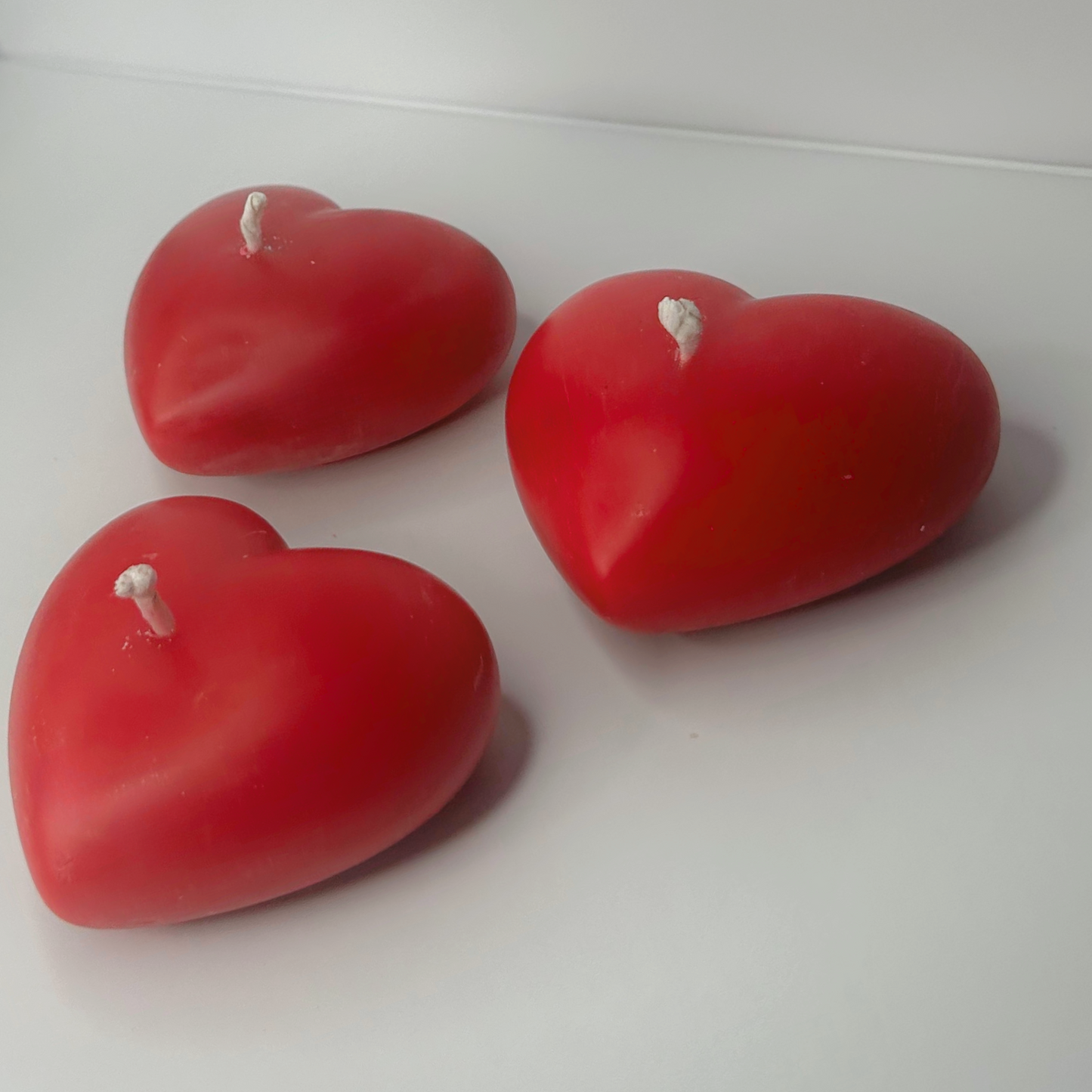 Side view of three Decorative Full-Heart Candles arranged with equal spacing, highlighting their height and heart shape.