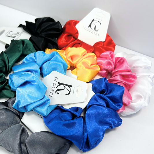 Silk scrunchies in a variety of vibrant and dark colors, showcasing a luxurious selection of hair accessories.