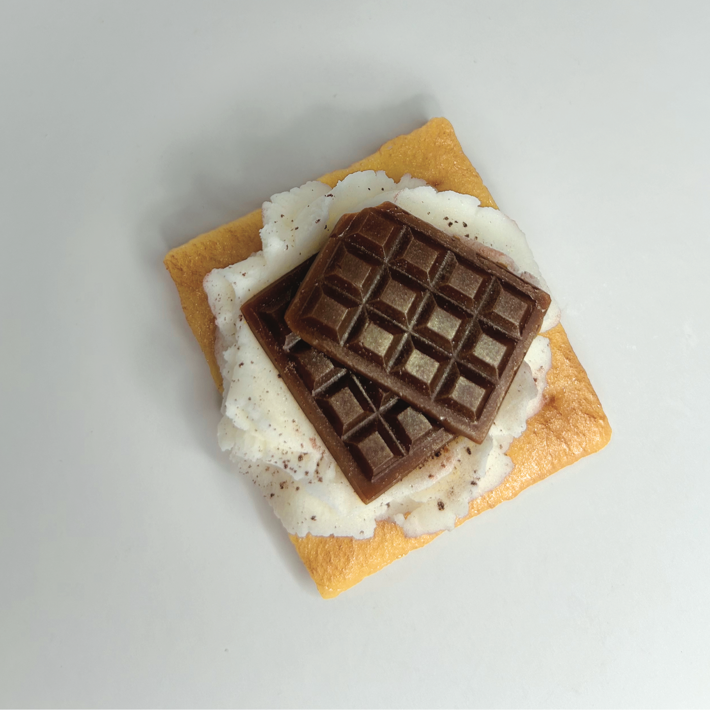 Top view of S'more Wax Melt showcasing toasted marshmallow, chocolate, and graham cracker design.