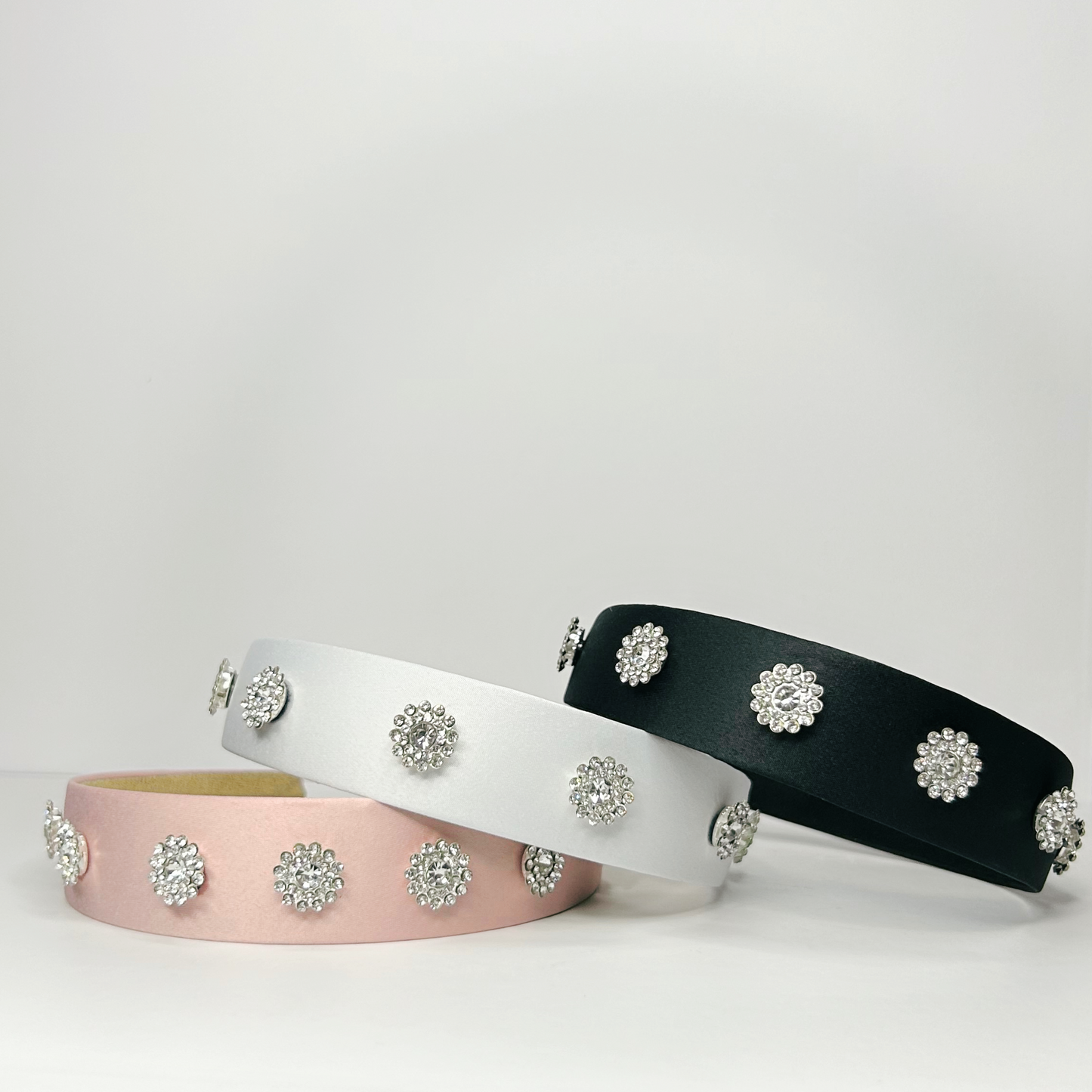 Stacked pink, black, and white sunflower headbands, showcasing vibrant floral designs and summer style.