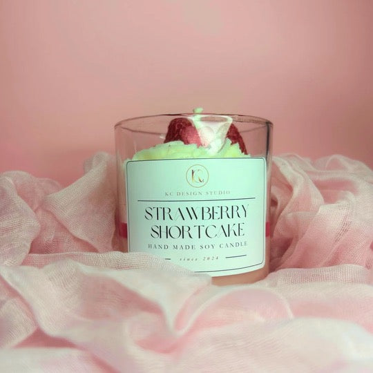 Strawberry Shortcake Candle placed in a cozy, soft setting with soft lighting, enhancing the ambiance with its delightful strawberry, caramel, and vanilla scents.