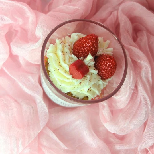 Top view of Strawberry Shortcake Candle showing the sparkly red sprinkles, two strawberries, and a mini heart on top.