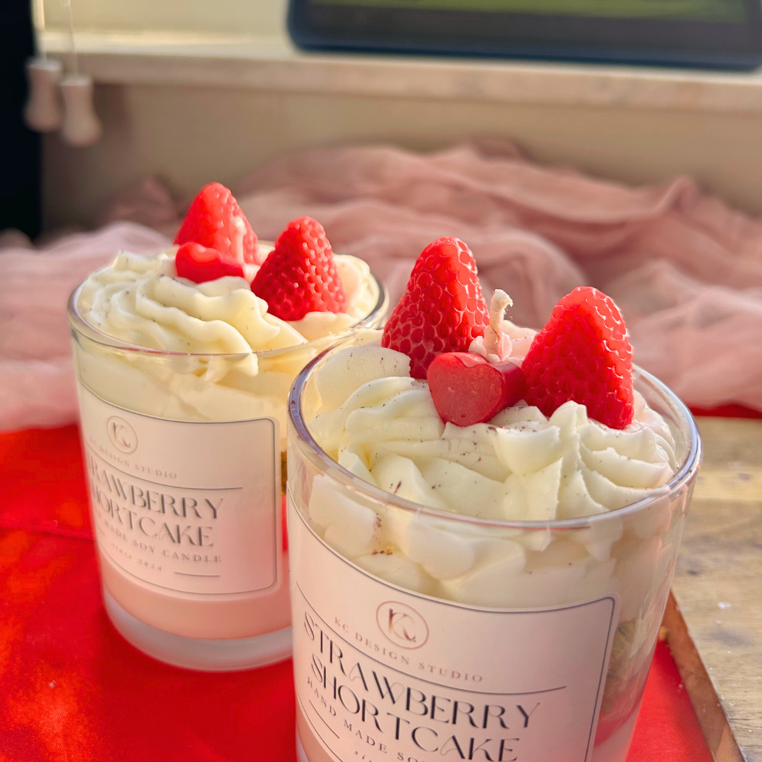 Top view of a strawberry shortcake candle with whipped cream details and realistic strawberry toppings.