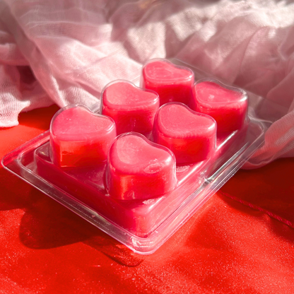 Angled back view of strawberry-scented heart wax melts, highlighting the smooth wax finish and adorable heart shape in a six-piece tablet.