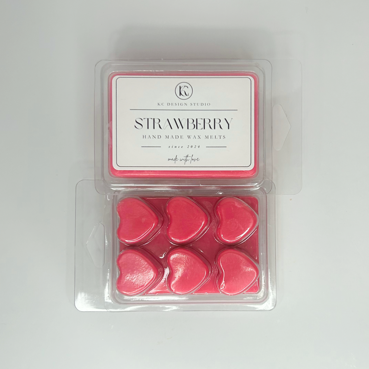 Top view of two packs of Strawberry Wax Melts, showcasing heart shapes and product label.