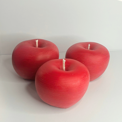 Three fresh, vibrant apples in shades of red, symbolizing the beauty of the Cranberry Apple Marmalade Candle.