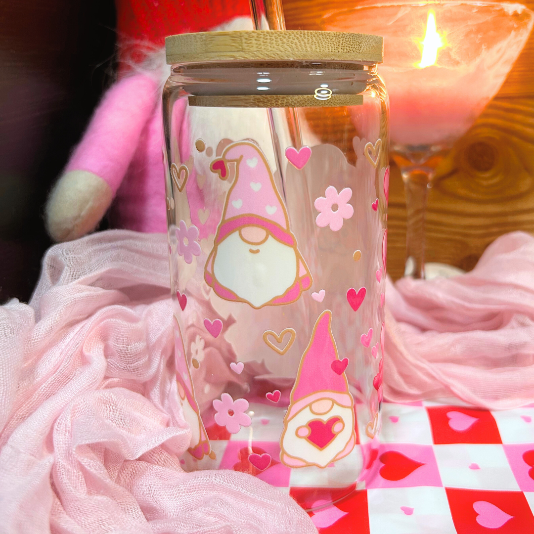 Glass jar with a gnome design and pink hearts on a checkered tablecloth.