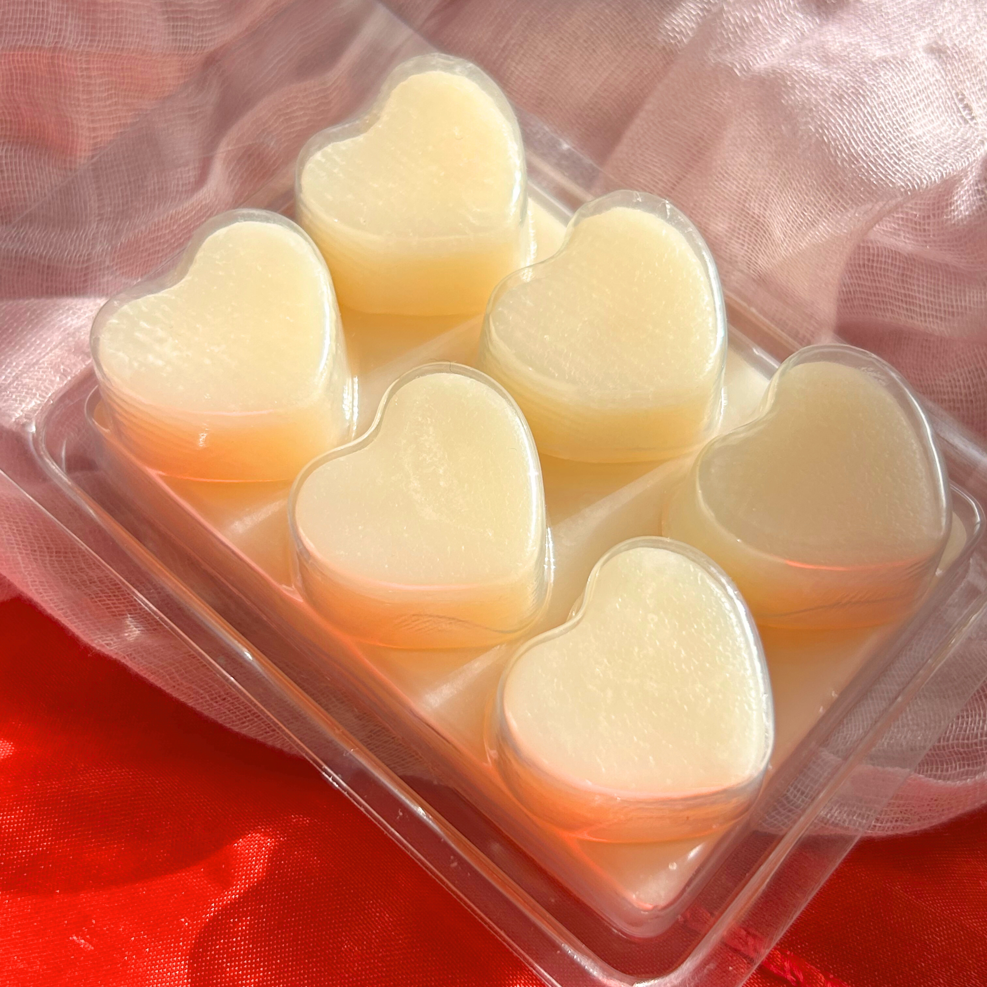 Back view of white cocoa butter wax melts, highlighting the smooth heart-shaped design in a six-piece tablet for easy melting and fragrance release.