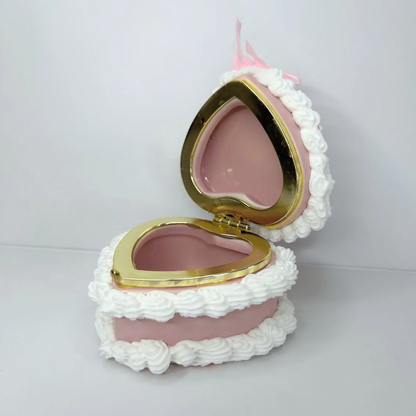 Open white mini cake jewelry box revealing a spacious interior for rings, earrings, and small treasures.