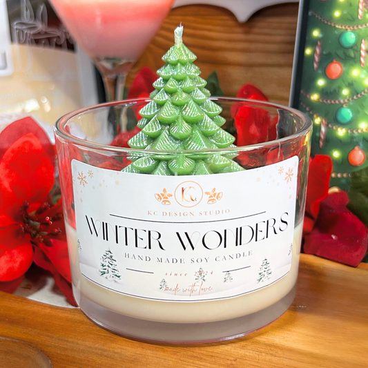 Handmade soy candle with a Christmas tree design on top, labeled 'Winter Wonders', on a wooden surface.